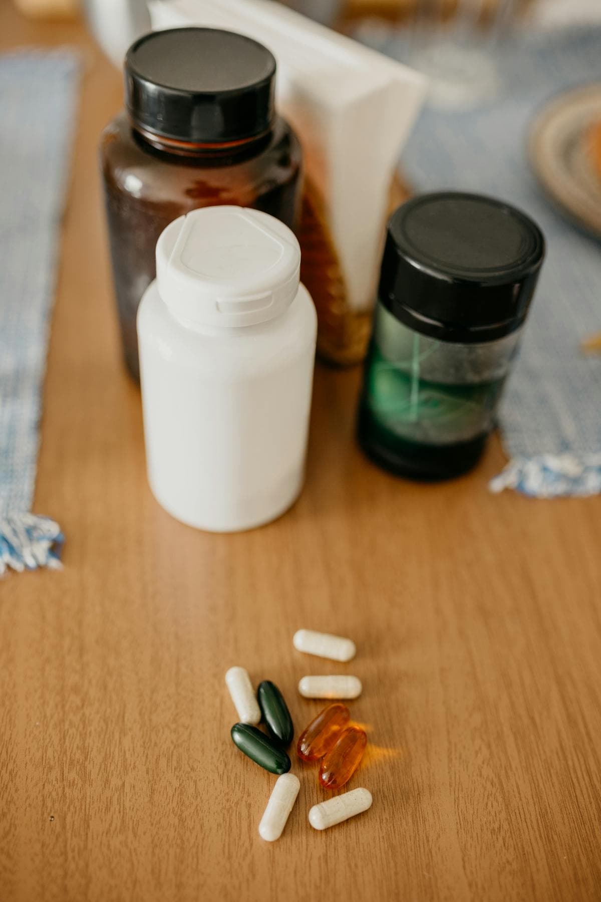 Frascos de suplementos e cápsulas sobre mesa de madeira